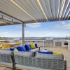 a rooftop area with a couch, chairs and a tv