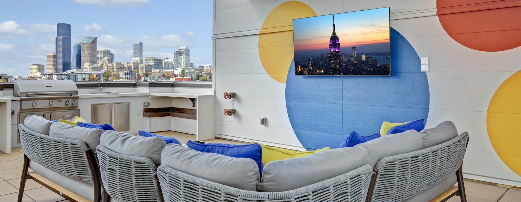 a rooftop lounge area with a couch and a tv