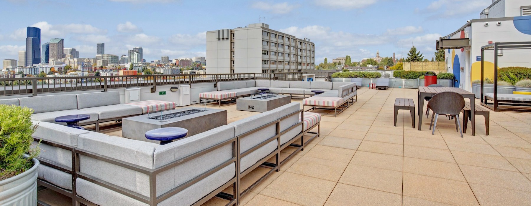 a deck with chairs and tables on it with a city in the background