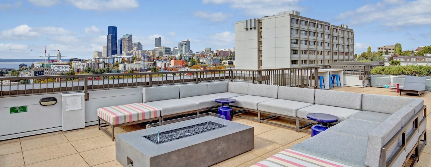 a rooftop area with a long couch and a table