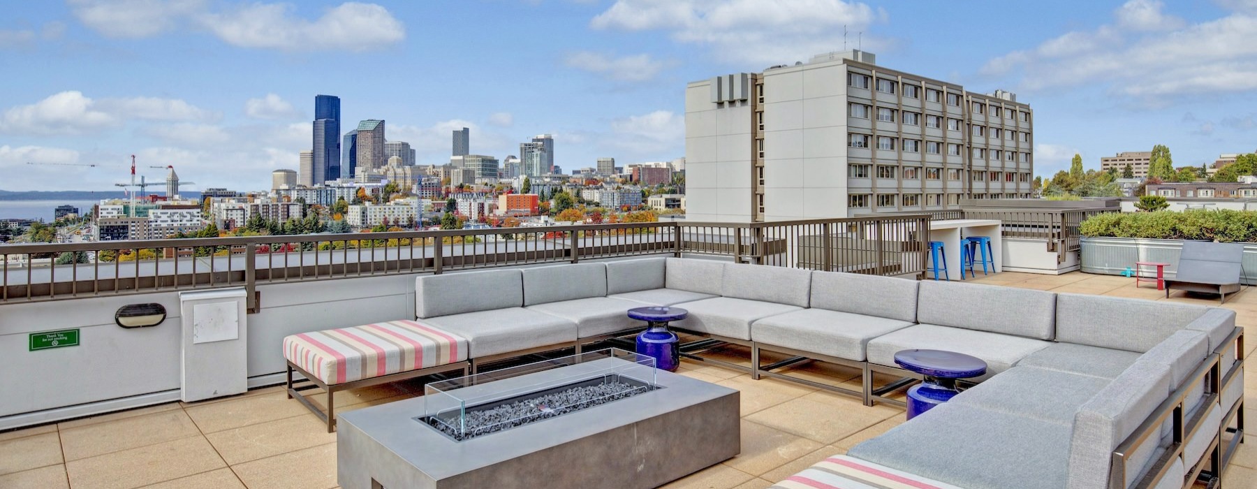 a rooftop area with a long couch and a table