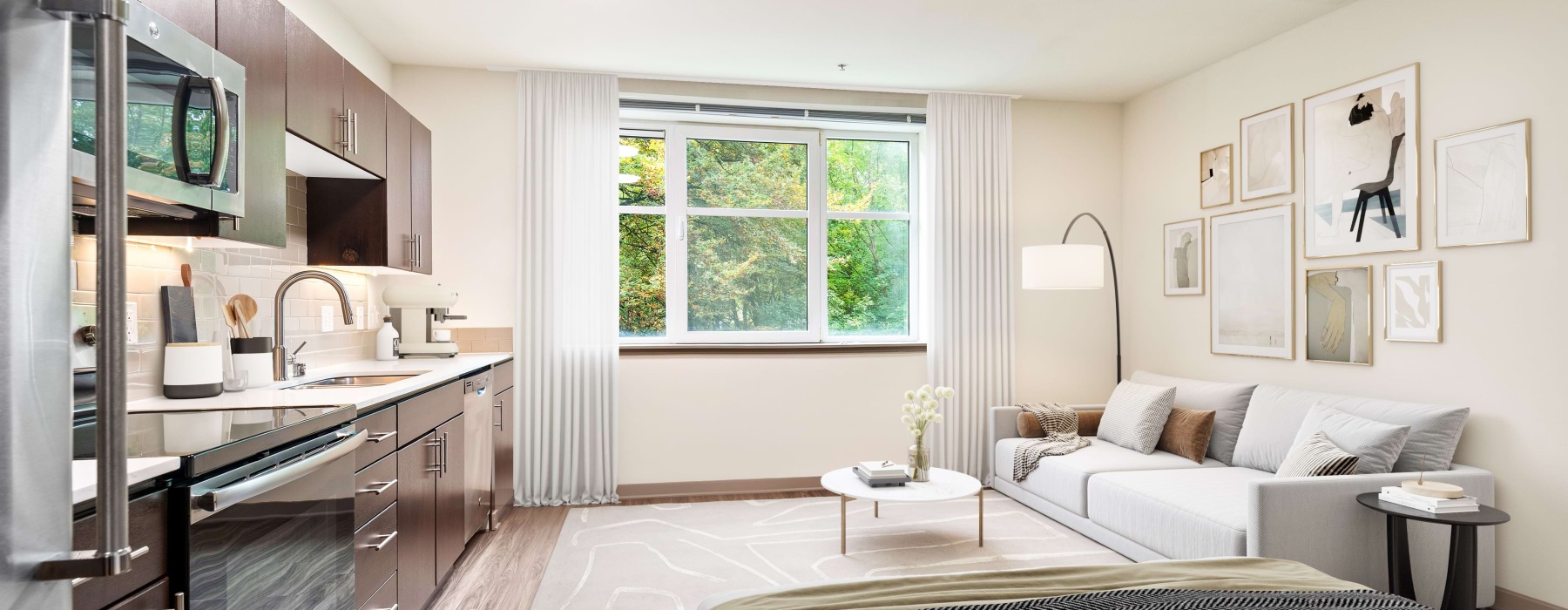 Studio Seattle apartment at Pratt Park with a bed, couch, and kitchen with a large window.